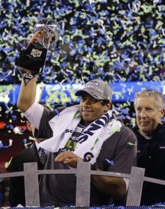 Seahawks quarterback Russell Wilson hoists the Vince Lombardi Trophy. Wilson went 18 of 25 for 206 yards and 2 touchdowns in the Seahawks' 43-8 shellacking of the Denver Broncos. (Photo from newsobserver.com)